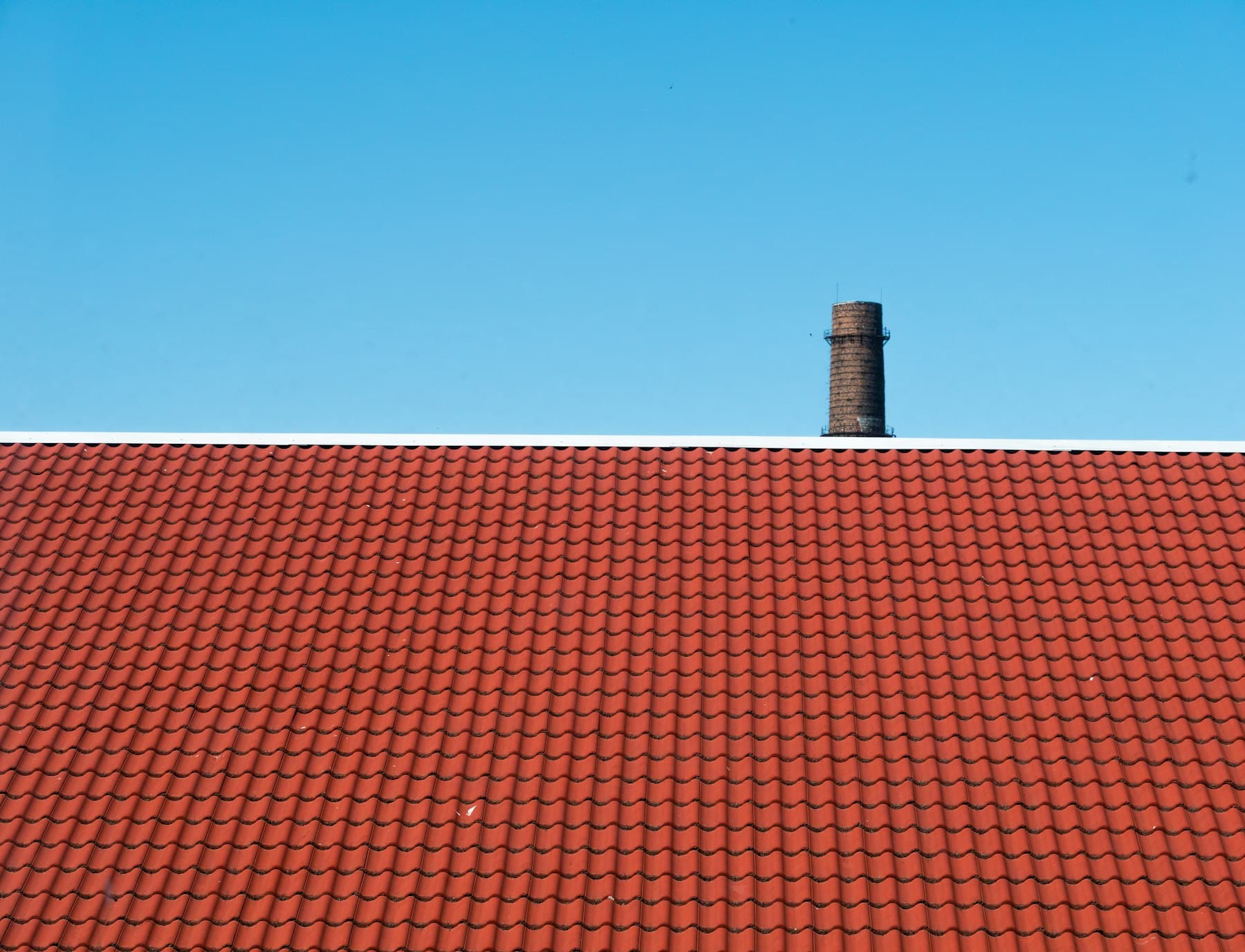 Braunes Ziegeldach vor blauem Himmel nach der Sanierung