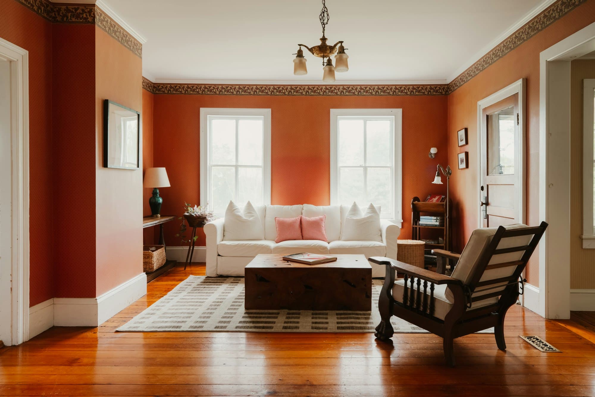 Heller Wohnraum mit orangefarbener Wand und weißem Sofa